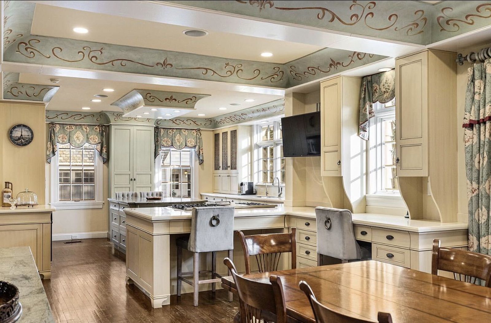 Before: cream cabinets with stenciled ceiling beams and patterned valances