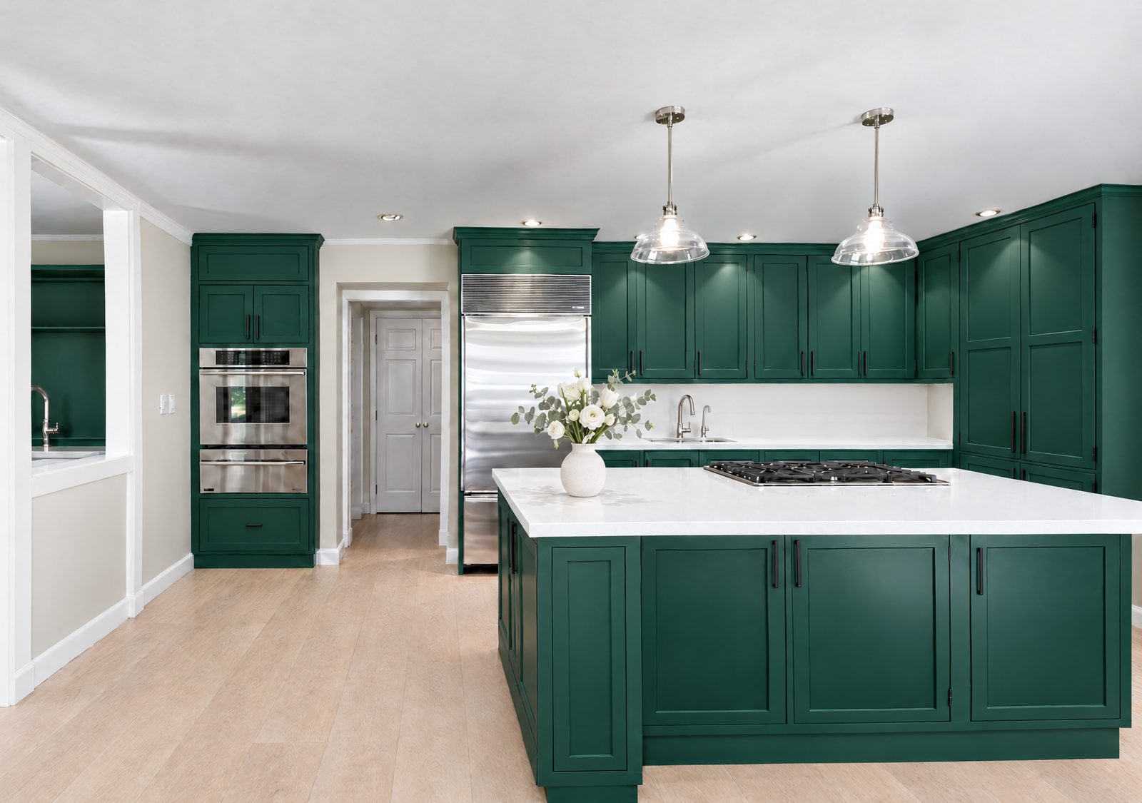 After: the same kitchen refinished in deep forest green with black hardware
